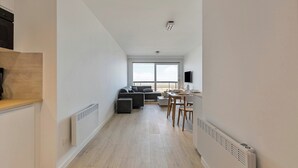 Een modern appartement met keuken, eethoek en zithoek.