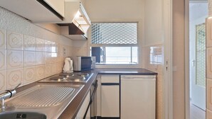 A compact kitchen with a stove, microwave, and dishwasher. - Flat in Blankenberge near Belgium Pier (BLANKENBERGE)