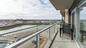 A balcony with a view of a canal and buildings in the distance. - Apartment in Blankenberge near Belgium Pier (BLANKENBERGE)