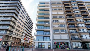 Un edificio de varios pisos con balcones, una tienda en la planta baja y un cartel que dice "MARINA TOWER".