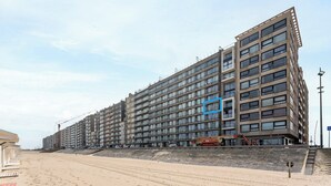 A multi-story building with a modern architectural design, featuring a series of balconies and large windows.