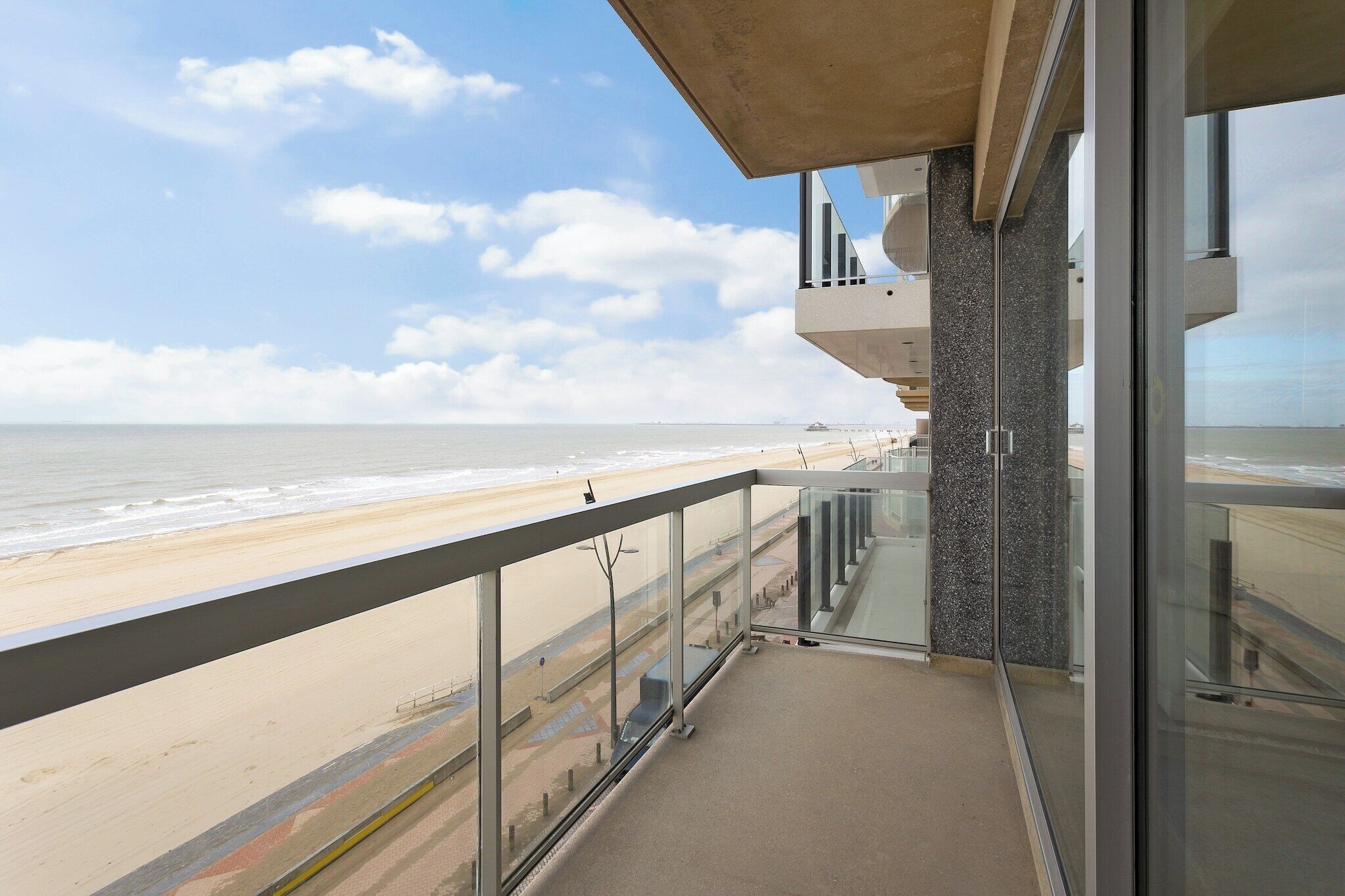 Een balkon met uitzicht op het strand en de oceaan.
