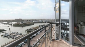 Un edificio alto con vistas a un puerto deportivo y un río.