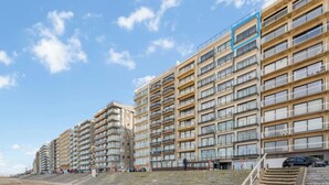 A multi-story hotel with balconies, a beach view, and a staircase leading to the beach. - Apartment in Blankenberge with Sea Views (BLANKENBERGE)