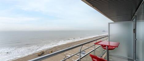 Un balcón con vista a la playa y al océano.