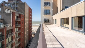 A modern building with multiple floors, balconies, and large windows. - Flat in Bruges with Panoramic City Views (BLANKENBERGE)