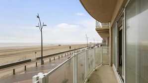 A balcony with a view of the beach, a glass door, and a street lamp. - Apartment in Blankenberge by the Marina (BLANKENBERGE)