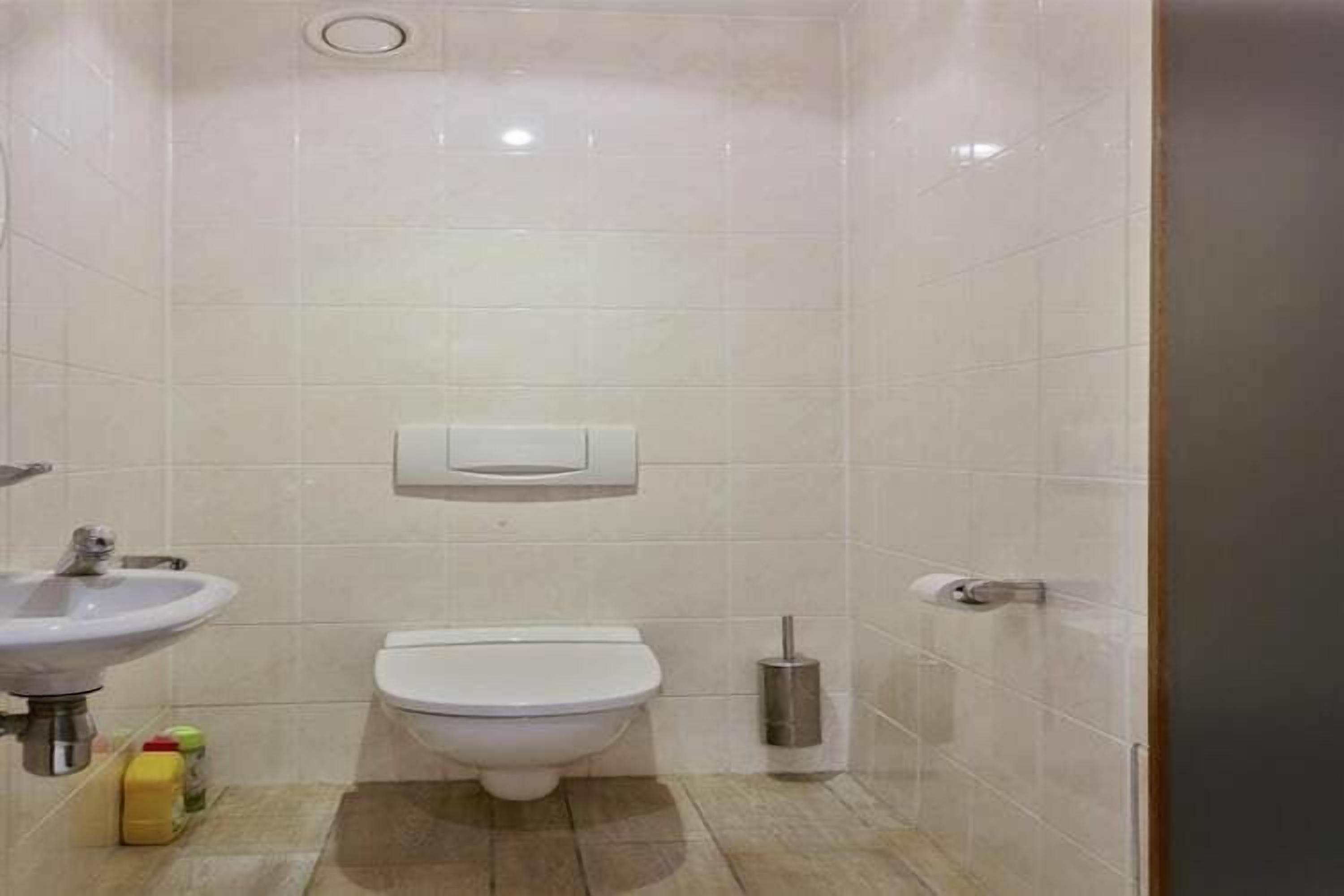 Un baño pequeño con inodoro, lavabo y secamanos.