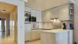 Una cocina moderna con una isla central, electrodomésticos integrados y un diseño minimalista.