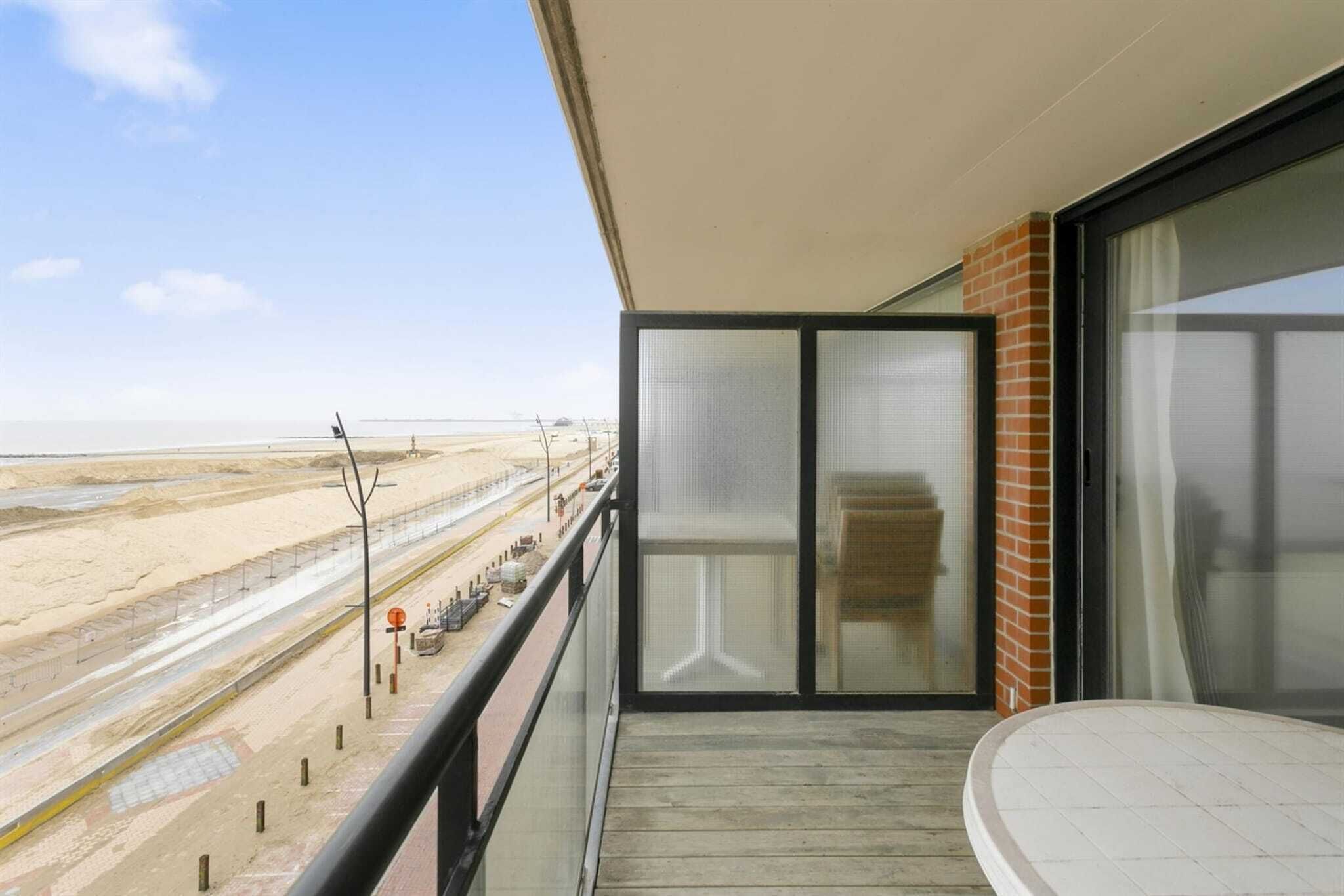 A balcony with a view of a beach and a road.
