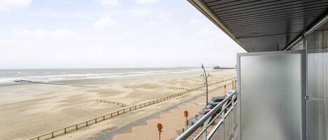 A balcony with a view of a beach and ocean.