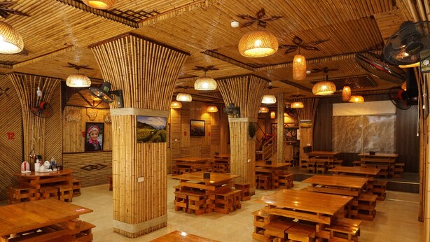 A restaurant with bamboo-themed decor, wooden tables, and hanging lights. - SaPa Marigold Hotel (Sa Pa)
