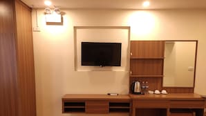 A modern bathroom with a wooden vanity, a mounted TV, a mirror, and a shelf with toiletries. - SaPa Marigold Hotel (Sa Pa)