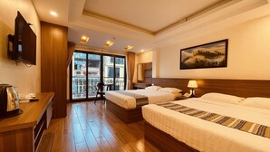 A hotel room with two beds, a desk with a kettle, a TV, and a balcony with a city view. - SaPa Marigold Hotel (Sa Pa)