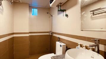 A bathroom with a toilet, sink, and shower.