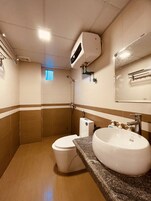 Un baño con inodoro, lavamanos y ducha.