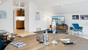 A modern living room with a round wooden coffee table, a blue armchair, and a large flat-screen TV. - "Frithlef" - 1.3km from the sea by Interhome (Græsted)