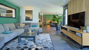 A modern living room with a sofa, coffee table, and a TV. - Villa with swimming pool and Jacuzzi, ideal for families, beach 10 min away, residential (La Crau)