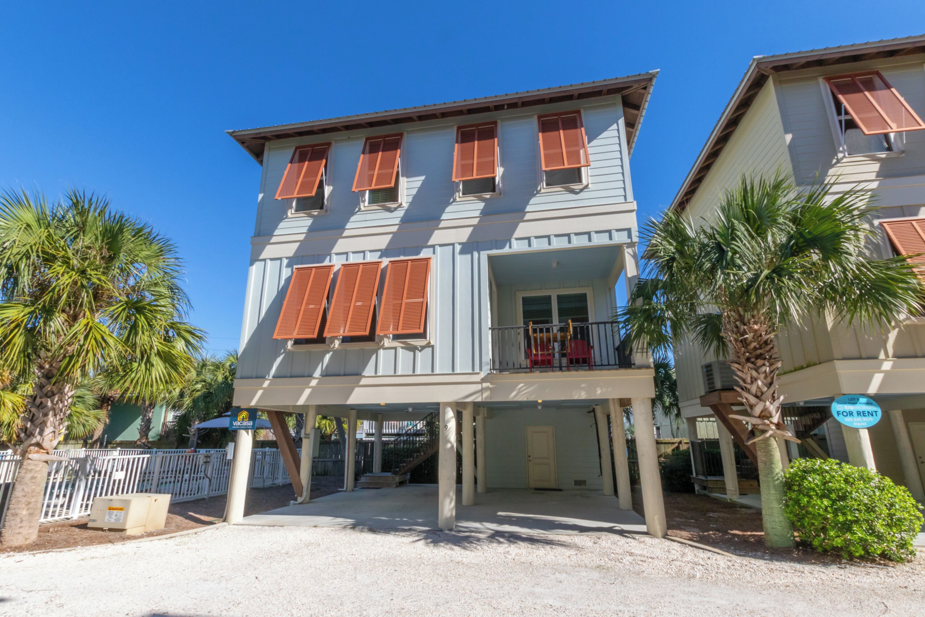 A two-story building with a balcony, a door, and a sign indicating it's for rent.