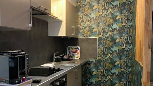Cocina compacta con microondas, estufa y lavamanos.