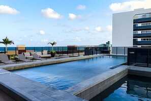 2 ulkouima-allasta, aurinkotuoleja