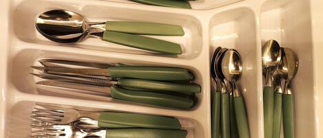 A kitchen sink with various utensils neatly arranged in compartments.