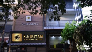 Ein Gebäude mit einem Schild, auf dem 'SV Residency' und 'Rajkiyam Business Hotel' steht.