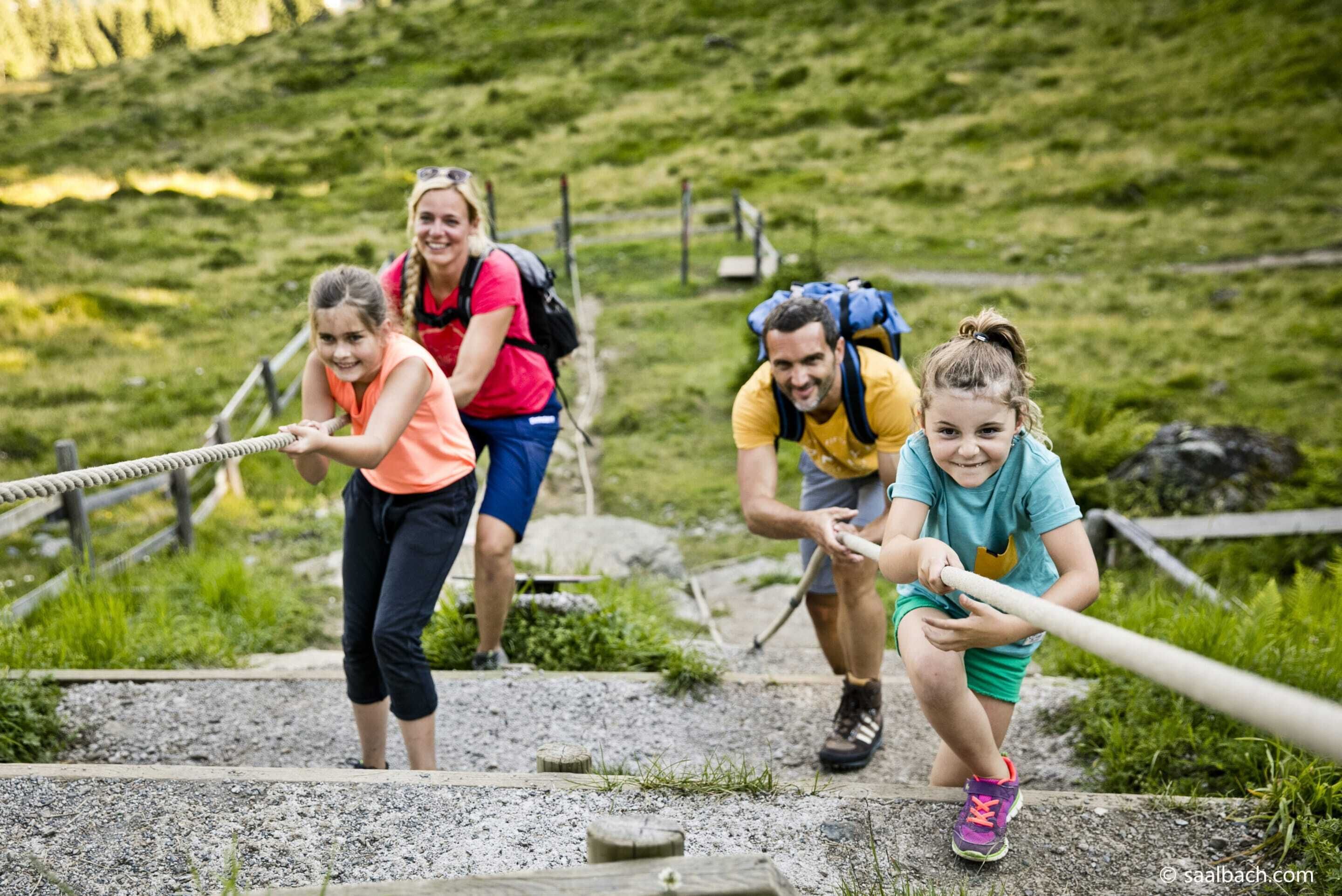 A group of people on a hiking trail with wooden steps and railings.