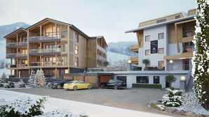 A modern multi-story hotel with balconies, a ski resort sign, and a snowy landscape. - Exclusive Suite in the ski Area (Saalbach-Hinterglemm)