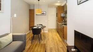 A compact living space with a dining area, kitchenette, and a sofa. - Cozy and quiet apartment (Barcelona)