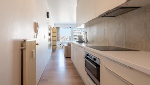 Una cocina moderna con vistas a la ciudad, horno empotrado y un amplio ventanal.