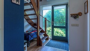 Eine Treppe führt zu einem Raum mit Blick auf Grünfläche.