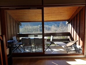 A room with a large sliding glass door leading to an outdoor patio with a table and chairs.