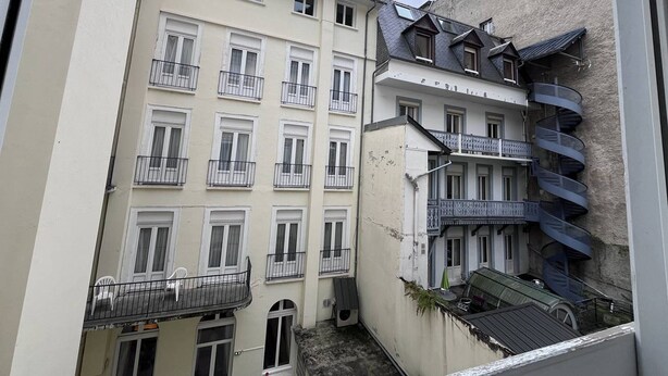 A multi-story building with balconies, a spiral staircase, and a small outdoor seating area.