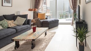 Ein modernes Wohnzimmer mit einem grauen Sofa, einem Couchtisch und einer TV-Konsole.