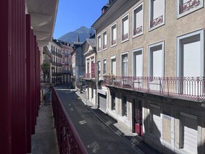 A narrow street lined with buildings, including a red building on the left and a building with a sign 'CATENA' on the right.