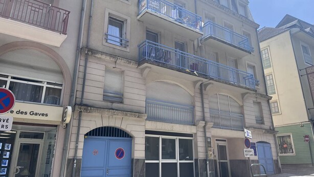 A multi-story building with balconies, a blue door with a no parking sign, and a storefront with a sign that reads "Les Gaves". - T2 for 4 people, parking, Cauterets (Cauterets)