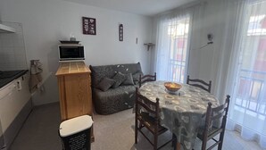 A compact living space with a kitchenette, a sofa, a dining table, and a window with curtains. - T2 for 4 people, parking, Cauterets (Cauterets)