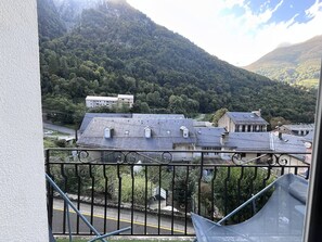 Un balcon avec vue sur la ville et les montagnes.