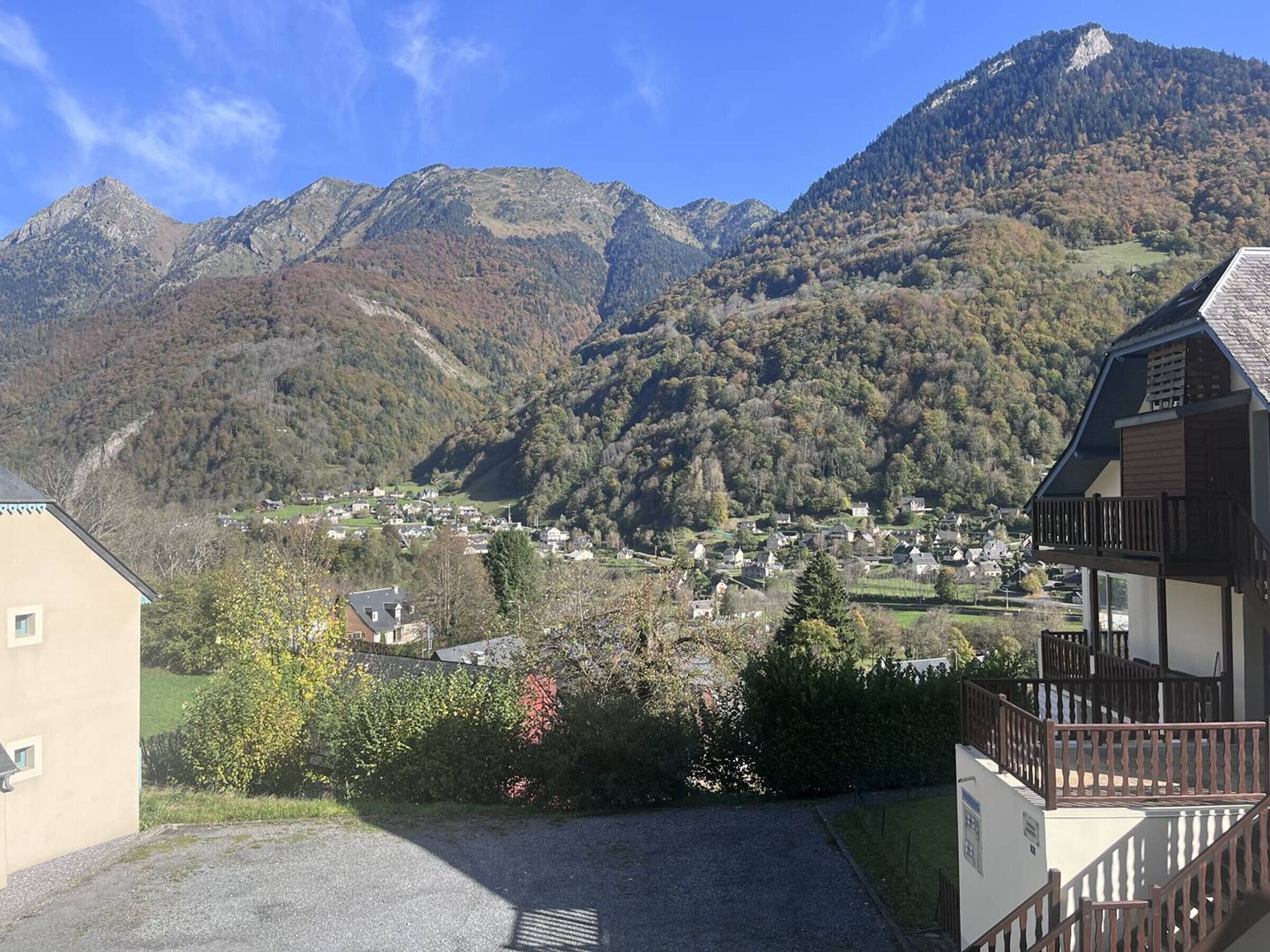 A mountain village with traditional architecture, a clear sky, and a view of the surrounding hills.