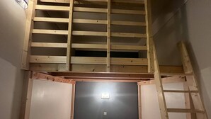 A small, enclosed room with a sloped ceiling, two beds, and a ladder. - Bright apartment with 2 bedrooms in Cauterets center (Cauterets)