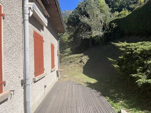 A building with a wooden deck and a gravel path leading to a hillside. - Spacious House in Cauterets: 4 Bedrooms, Garage, No Pets (Cauterets)