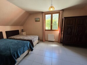 A bedroom with two beds, a radiator, a window with curtains, and a wardrobe. - Spacious House in Cauterets: 4 Bedrooms, Garage, No Pets (Cauterets)