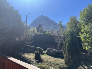 Een bergachtig landschap met heldere lucht, een stenen muur en een houten omheining.