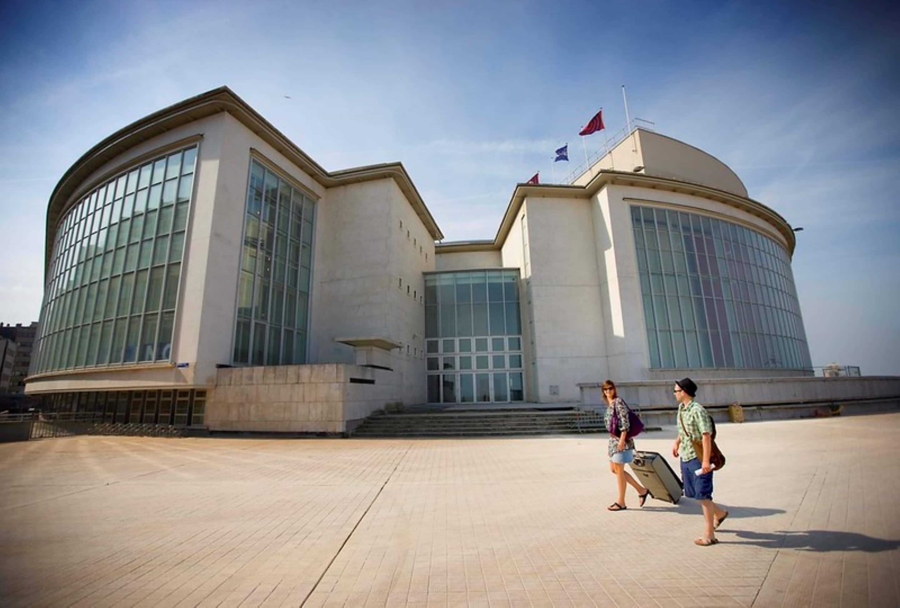A modern building with large glass windows and a dome structure.