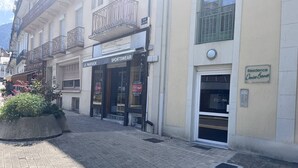 A street view with a sportswear store named 'Le Paddock' and a residential building with a sign 'Résidence Denise Bernet'. - Cozy apartment in Cauterets with terrace and ski storage (Cauterets)