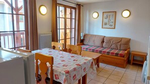 Una habitación acogedora con una mesa de comedor, sillas, un sofá y un radiador.