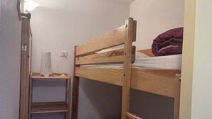 A bunk bed with a wooden frame and a shelf below. - Family apartment in Cauterets with balcony, ski locker, perfect for 4 guests (Cauterets)