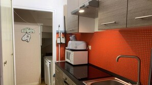 A compact kitchen with a microwave, toaster, and sink.