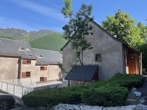 A building with a sloped roof, a small window, and a door.